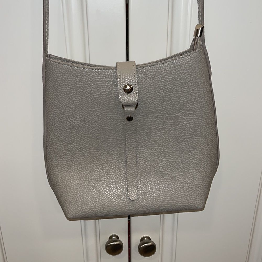 Grey small purse with cross body strap with zipper top and claps